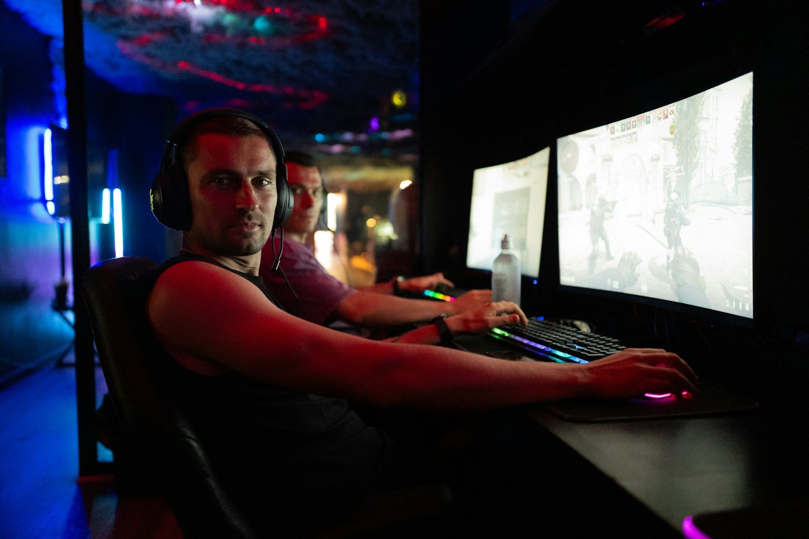 Men playing video games in a dimly lit room.